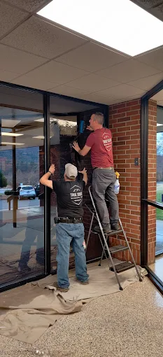 Two True South installers working on a commercial storefront